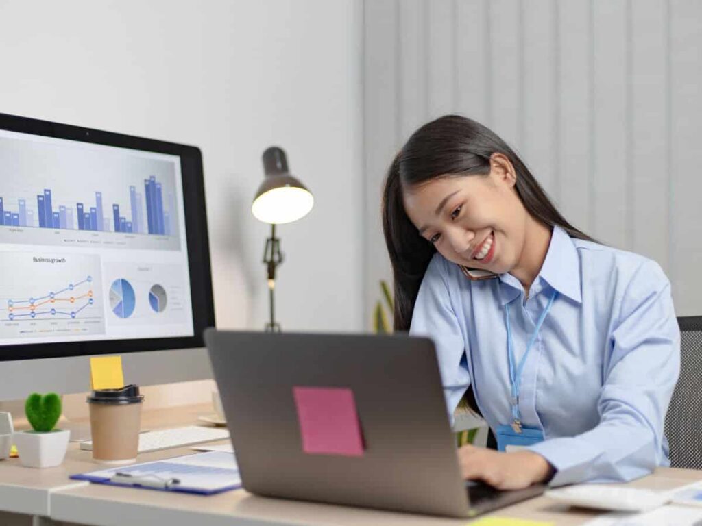 lady sitting at her desk typing on her laptop