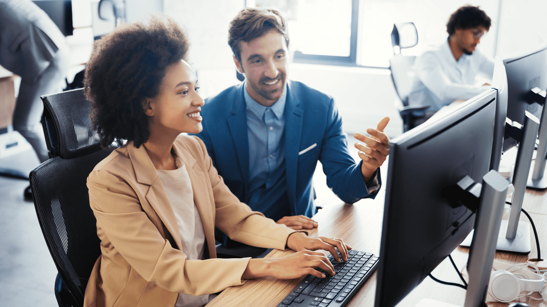 A woman and man sitting behyind a computer having a conversation